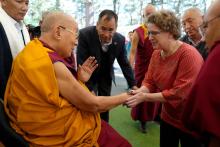 Professor Emily Bender shakes hands with the Dalai Lama