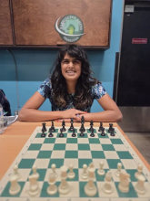 Photo of a woman in front of a chess board