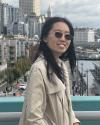 image of a woman with dark hair wearing dark sunglasses in front of a city background