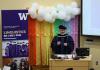 Richard Wright speaking at graduation next to the Linguistics banner.