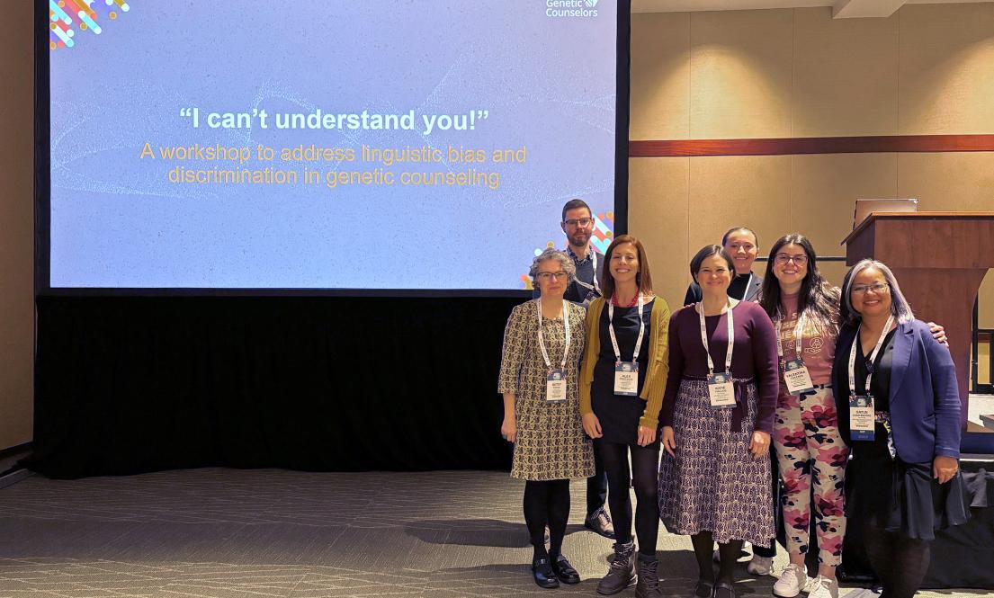 A group of people at a conference standing and smiling